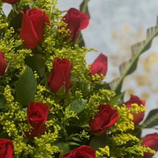 Primer plano extremo de un arreglo floral con rosas Cupido rojas, mostrando texturas hiperrealistas, gotas de rocío y colores
