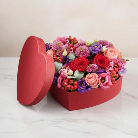 Arreglo Floral ZITA: Caja Corazón con Rosas y Flores Mixtas 💝 Arreglo floral ZITA en caja de corazón roja con rosas rojas, rosadas y flores mixtas, ideal para regalar en ocasiones especia