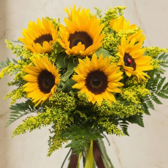 Primer plano extremo de un bouquet de girasoles LAIA con 10 flores, mostrando texturas hiperrealistas, gotas de rocío y color