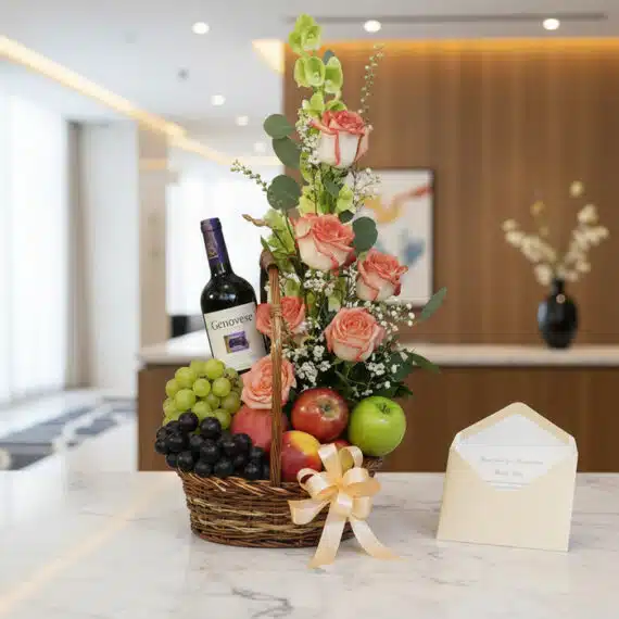 Canasta gourmet CAPRICE con rosas frescas, uvas verdes y negras, manzanas rojas y verdes, duraznos, vino tinto Genovese, tarj