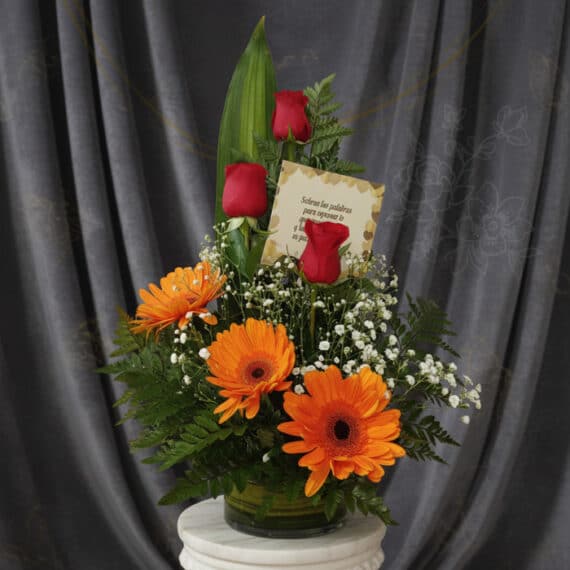 Arreglo floral 'Solitario Tu Recuerdo' con tres rosas rojas, tres gerberas naranjas, follaje verde y flores blancas pequeñas,
